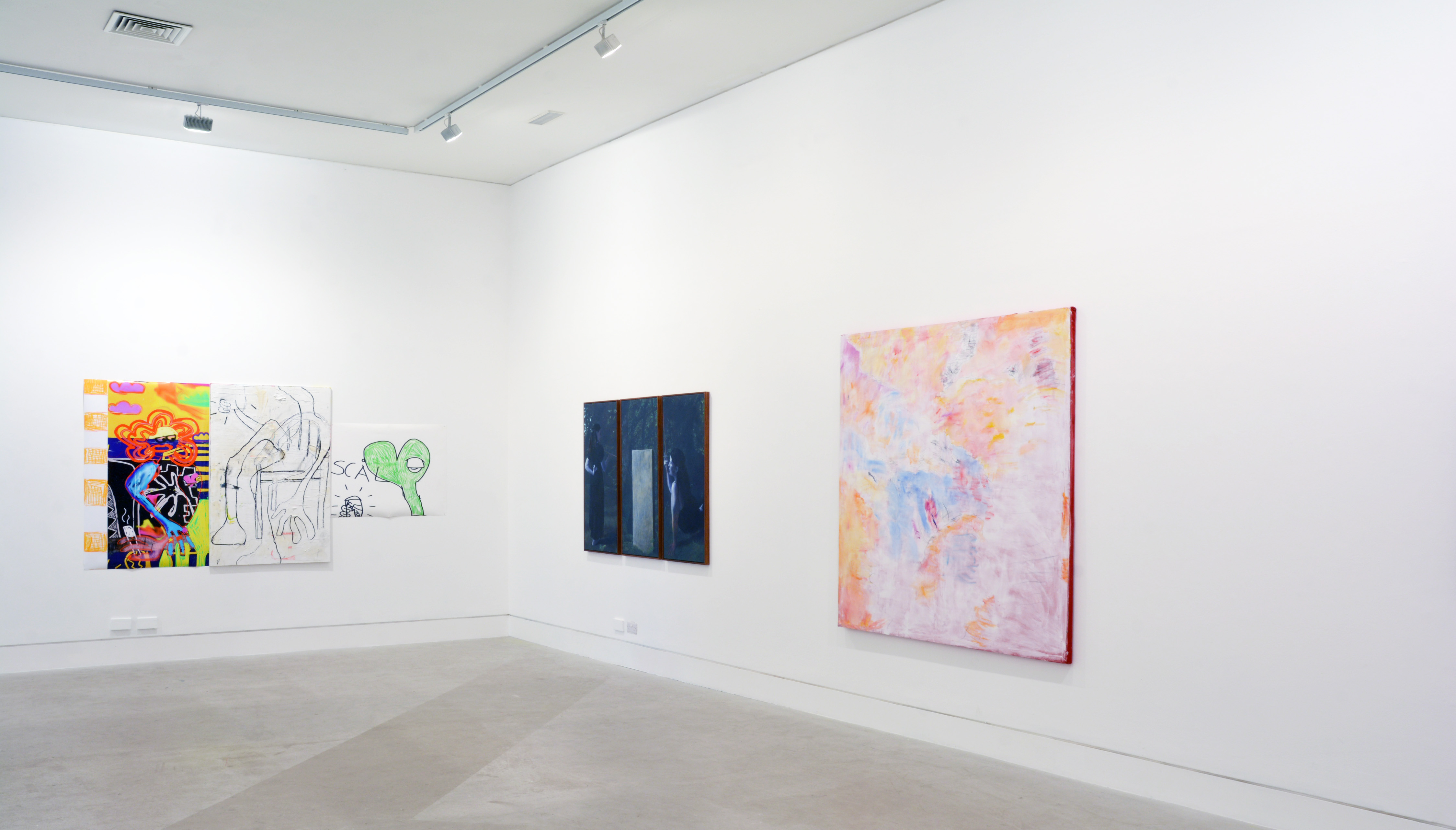 A selection of paintings hanging in a white walled gallery space.